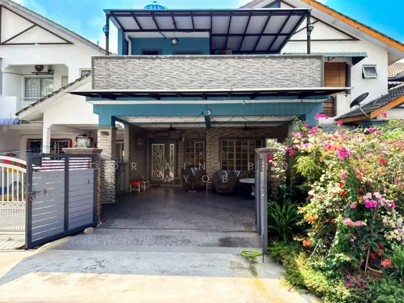 Exterior type: linked terrace house; features: grey stone cladding on facade, blue painted accents, flat roof, covered car porch, manicured garden with flowering plants, paved driveway, security gate, front porch with seating area; style: modern.