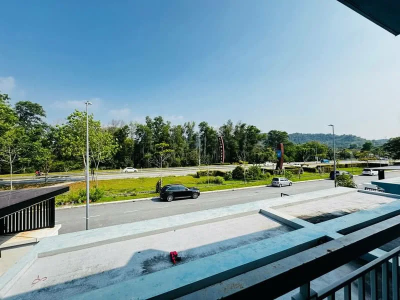 Exterior features: open road view, greenery along the roadside, trees lining the area, clear blue sky, paved road, car parked in view, signage visible in the background.