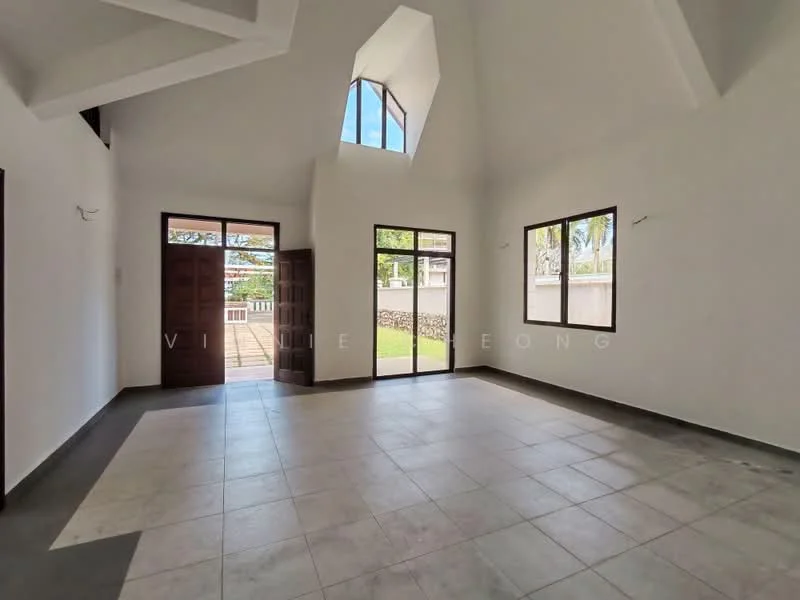 Room features: white painted walls, high ceiling with angular design, large windows allowing natural light, grey tiled flooring, double wooden doors, view of outdoor space through windows, no visible furniture, open layout; style: modern; view: garden.