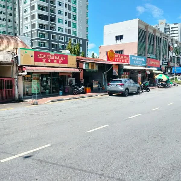 Exterior type: shophouse; features: single-storey shophouses, facade with signage, street-level access, outdoor seating area, paved walkway, parking spaces, nearby residential high-rise buildings, urban street view; style: traditional.