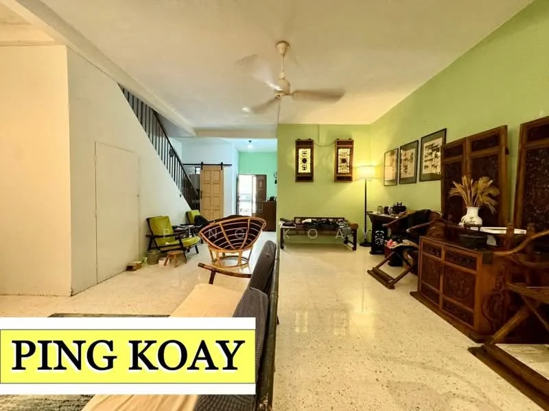 Living features: green painted walls, polished concrete flooring, 5-blade ceiling fan, sofa with beige upholstery, wooden coffee table, decorative wooden furniture, framed artwork on walls, open space layout; style: traditional. Room features: staircase leading to upper floor, additional seating area with chairs.