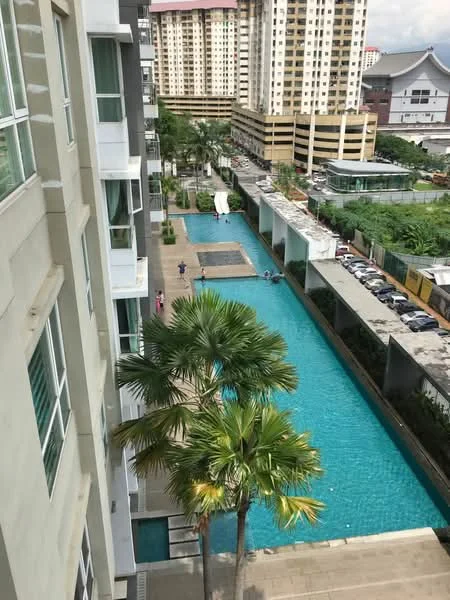 Exterior type: high-rise condominium; features: swimming pool, landscaped pool deck, palm trees, manicured lawn, surrounding high-rise buildings, outdoor seating area, water feature, parking area, walkway beside pool; style: modern.