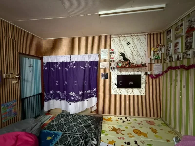 Room features: wood paneling on walls, striped wallpaper, purple curtain, flat-screen TV mounted on wall, decorative wall with marble pattern, carpet flooring, colorful area rug, framed photos on wall, decorative items on shelf, ceiling light fixture; style: traditional.