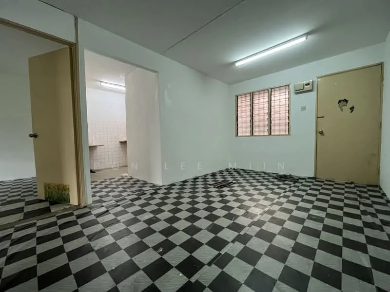 Room features: black and white checkered flooring, white painted walls, exposed ceiling, window with metal grilles, door with a peephole, wall-mounted air conditioning unit, light fixture on ceiling.