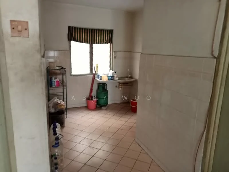 Kitchen features: white tiled walls, cream tiled flooring, single-bowl stainless-steel sink, chrome faucet, window with striped curtain, metal shelving unit, green plastic container, red bucket, cleaning supplies, wall-mounted light fixture.
