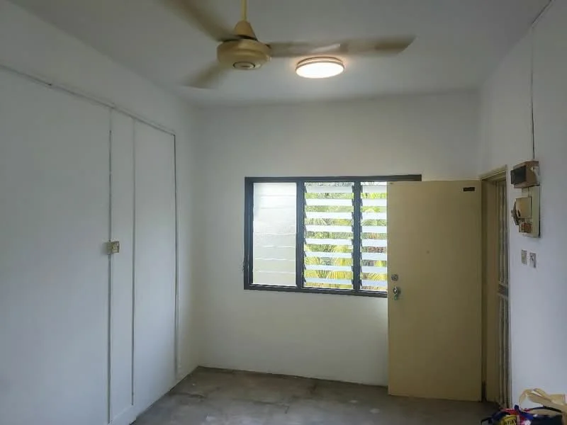 Room features: white painted walls, concrete flooring, ceiling fan, light fixture, window with louvered shutters, door with handle, built-in wardrobe with sliding doors.