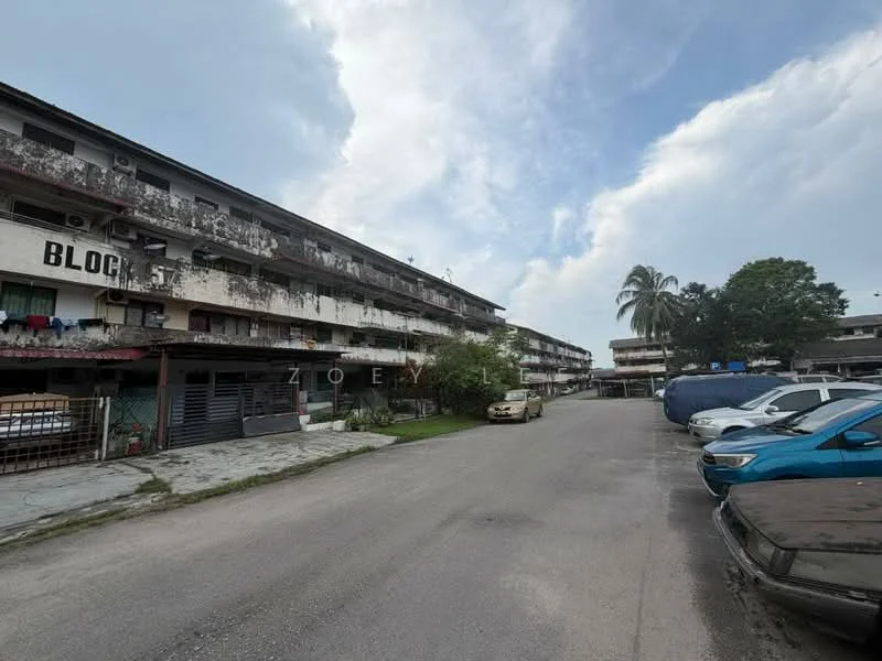 Exterior type: low-rise apartment block; features: two-storey building, concrete facade, balconies with metal railings, parking spaces visible, manicured lawn, paved walkway, surrounded by palm trees, street view, multiple vehicles parked, cloudy sky; style: traditional.