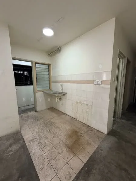 Room features: white painted walls, tile cladding on lower half of walls, grey concrete flooring, single-bowl stainless-steel sink, wall-mounted faucet, window with metal grille, light fixture on ceiling, dirty floor tiles.