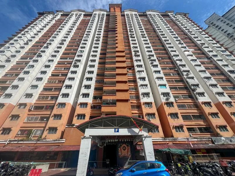 Exterior type: high-rise condominium; features: orange and white painted facade, multiple balconies, glass windows, main entrance with awning, ground-level parking area, surrounded by motorcycles, multiple storeys, urban setting; style: modern.