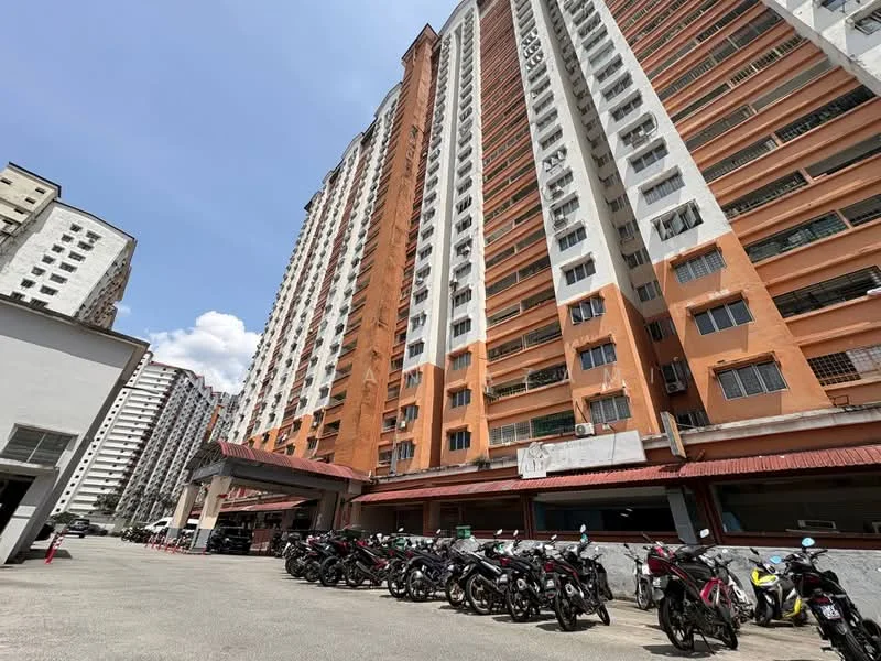 Exterior type: high-rise condominium; features: orange and white painted facade, multiple storeys, balconies visible, covered parking area, motorcycle parking, surrounding residential buildings, clear blue sky, urban setting; style: modern.