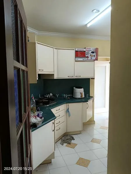 Kitchen features: L-shaped kitchen layout, cream cabinetry, green countertop, stainless-steel sink, built-in stove, microwave, white tiled backsplash, white tiled flooring, overhead fluorescent lighting, door leading to outside, kitchen appliances visible.