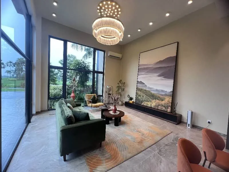 Living features: green fabric sofa, round coffee table, chandelier with multiple bulbs, large wall art with landscape, floor-to-ceiling windows, air conditioning unit, area rug with abstract pattern, decorative plants, wooden console table, orange upholstered dining chairs; style: modern; view: garden.
