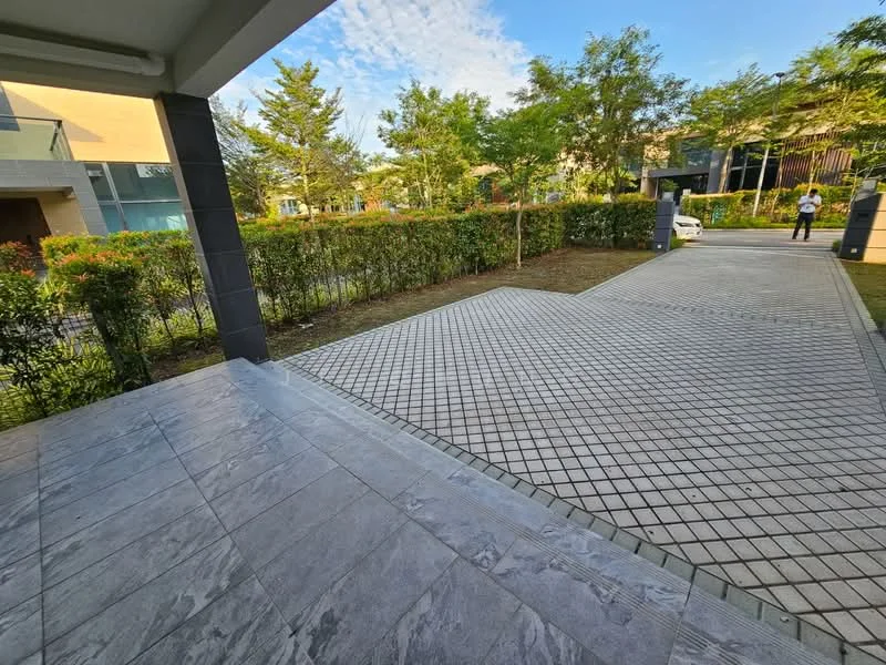 Exterior features: paved driveway, manicured hedges, landscaped garden, tropical trees, grey stone cladding, open space, clear blue sky; style: modern.