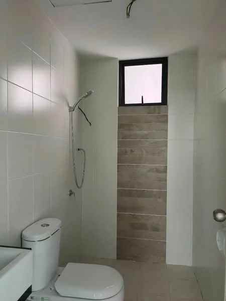 Bathroom features: white tiled walls, grey tiled flooring, walk-in shower with glass partition, chrome handheld shower, one-piece toilet, small window for ventilation, sink with modern faucet, neutral color scheme; style: modern.