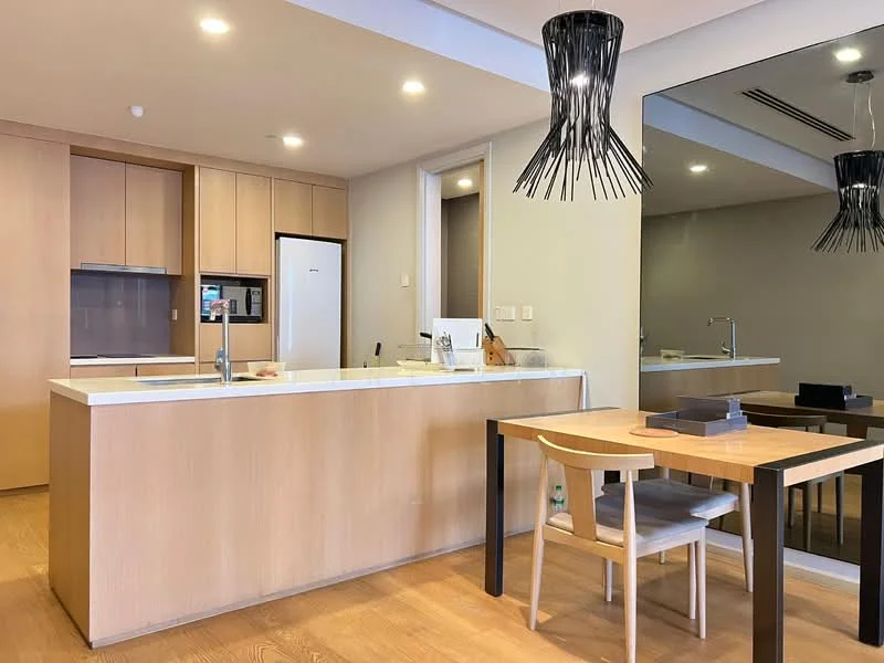 Kitchen features: light wood cabinetry, white quartz countertop, stainless-steel sink, chrome pull-down faucet, built-in oven, freestanding fridge, 4-burner gas hob, pendant light, open shelving, wooden flooring, mirror wall, dining table with 4 chairs; style: modern.