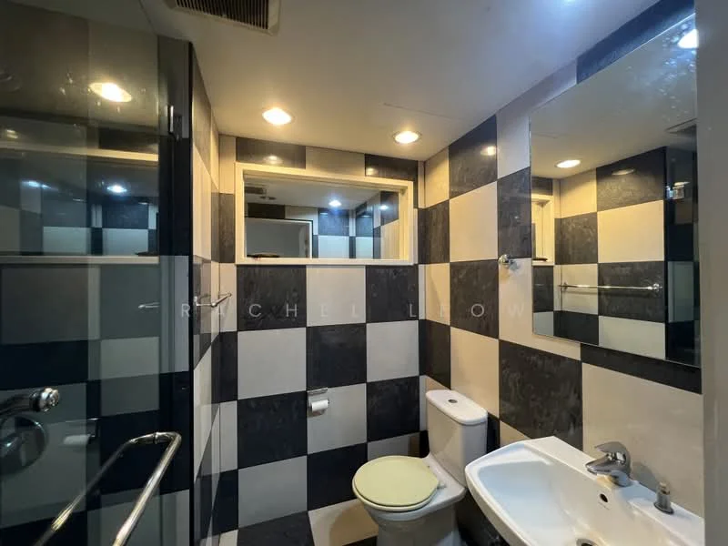 Bathroom features: black and white checkered wall tiles, glass shower enclosure, chrome shower head, single-sink vanity with white cabinet, chrome basin mixer faucet, framed mirror above sink, one-piece toilet, recessed downlights, towel rack, toilet paper holder; style: modern.