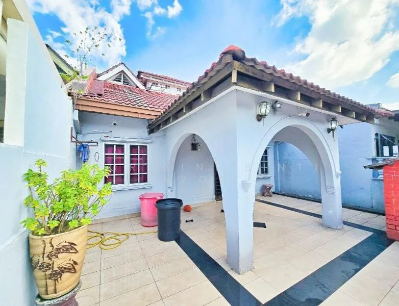 Exterior type: detached bungalow; features: arched entrance with columns, red tiled roof, white painted facade, outdoor tiled flooring, potted plant, outdoor lighting fixtures, exposed brick wall, manicured landscaping, water hose visible, black trash bin, pink trash bin; style: modern.
