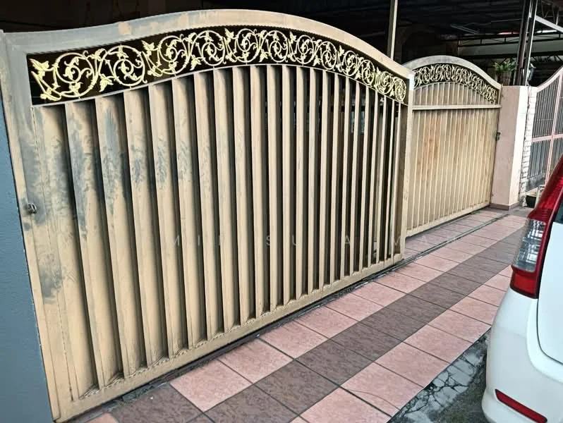 Exterior features: ornate metal gate with floral design, wooden slats, paved driveway, pink and brown patterned tiles, surrounding wall, car parked in driveway; style: traditional.