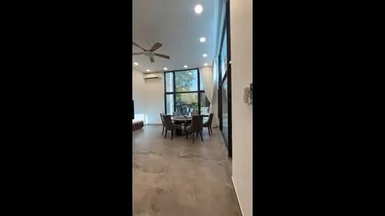 Dining features: dining table with 6 chairs, 5-blade ceiling fan, floor-to-ceiling windows, wall-mounted split AC, neutral wall colour, polished concrete flooring, decorative lighting, view of outdoor greenery; style: modern; view: garden.