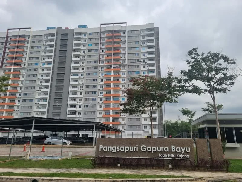 Exterior type: high-rise condominium; features: multi-storey building, concrete facade, white painted facade, orange and blue accents, covered parking area, landscaped entrance, signage at entrance, surrounded by greenery; style: modern.