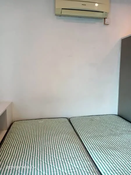Room features: white painted walls, 2 single mattresses with striped covers, wall-mounted split AC, built-in wardrobe, flooring not visible.