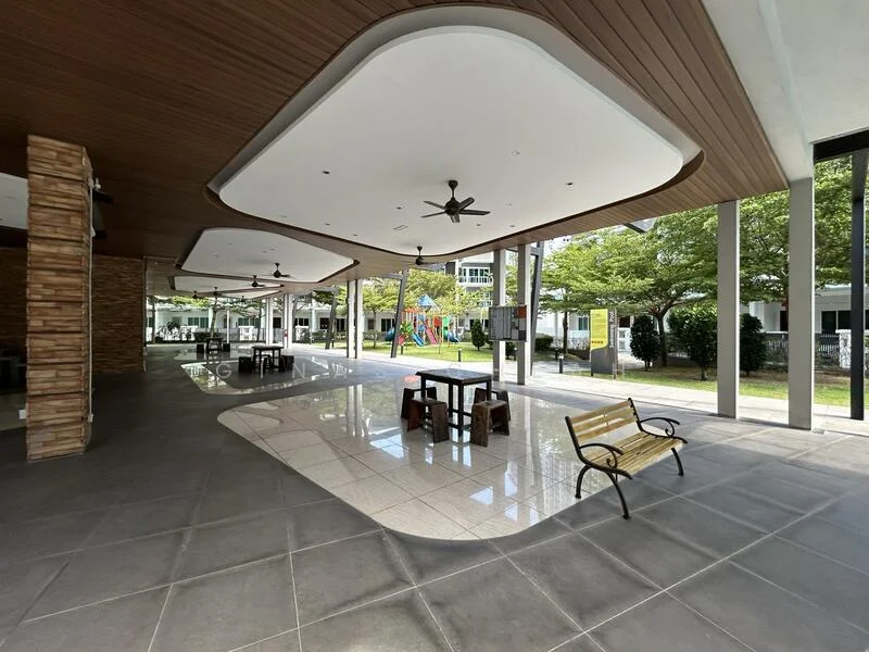 Exterior type: clubhouse; features: open-air seating area, ceiling with wooden panels, 2 ceiling fans, polished tile flooring, playground visible in background, landscaped garden area, benches for seating, glass walls, natural light from large openings; style: modern.