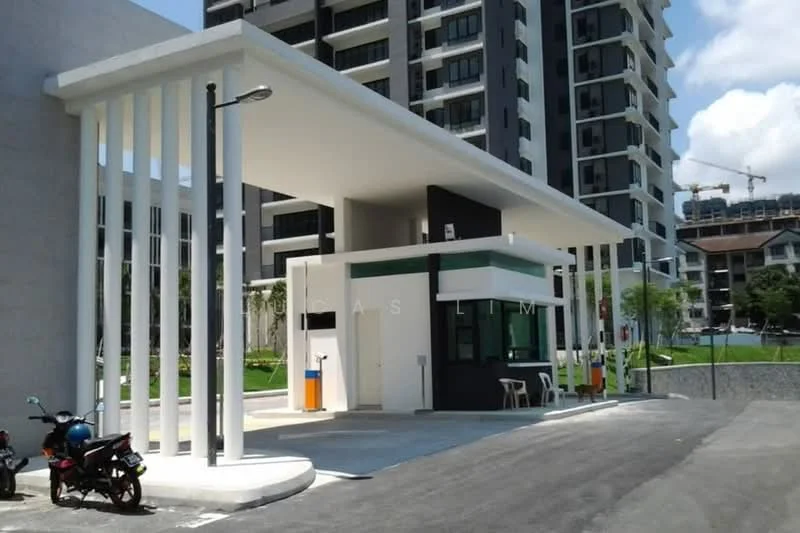 Exterior type: main entrance gate; features: modern guard house, white painted facade, black accent wall, flat roof, security booth with glass windows, paved driveway, street lighting, surrounded by landscaping, adjacent to high-rise buildings; style: modern.