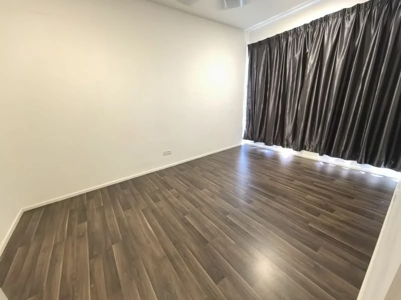 Room features: laminate flooring, white painted walls, floor-to-ceiling curtains in dark fabric, natural light from window.