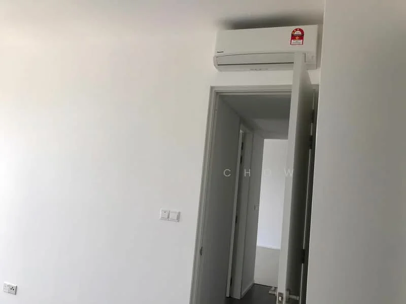 Room features: white painted walls, grey flooring, 1 wall-mounted split AC, doorway leading to another room, light switch, door frame.