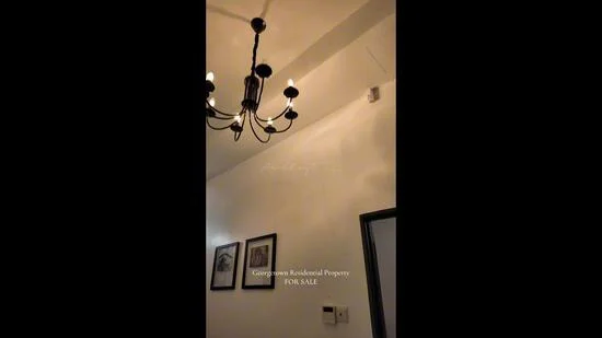 Room features: chandelier, white painted walls, framed artwork, wall-mounted light switch.