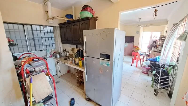 Kitchen features: stainless-steel fridge, wood cabinetry, countertop with sink, stainless-steel sink, kitchen utensils on countertop, open shelving, tile flooring, window with metal grille, ceiling fan, multiple pots and pans, plastic containers, kitchen appliances, dining table in adjacent area.