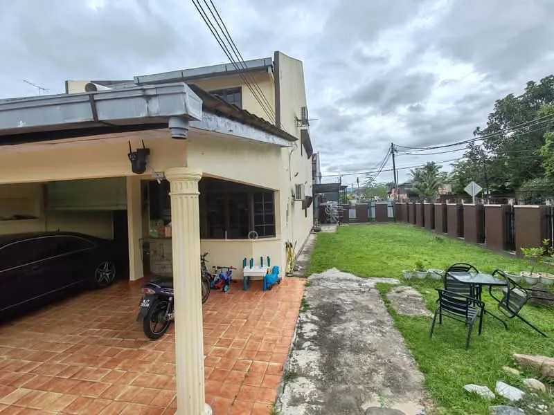 Exterior type: semi-detached house; features: tiled flooring in car porch, manicured lawn, stone-paved walkway, fenced perimeter, single-storey structure, outdoor seating area with chairs, bicycle and motorcycle visible, garden area, overcast sky; style: modern.