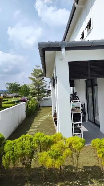 Exterior type: linked terrace house; features: white painted facade, flat roof, manicured lawn, landscaped garden with shrubs, paved walkway, outdoor space beside the house, windows with black shutters, surrounded by greenery; style: modern.