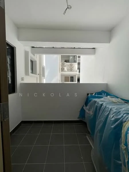 Room features: white painted walls, grey tiled flooring, window with view of exterior, wall-mounted air conditioning units, exposed ceiling, plastic covering on furniture, light fixture, open space layout.