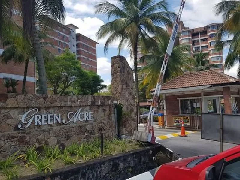 Exterior type: gated community; features: stone-clad entrance gate, signage with 'GREEN ACRE', guard house at entrance, palm trees, manicured landscaping, multi-storey residential buildings in background, paved driveway, security boom gate; style: modern.
