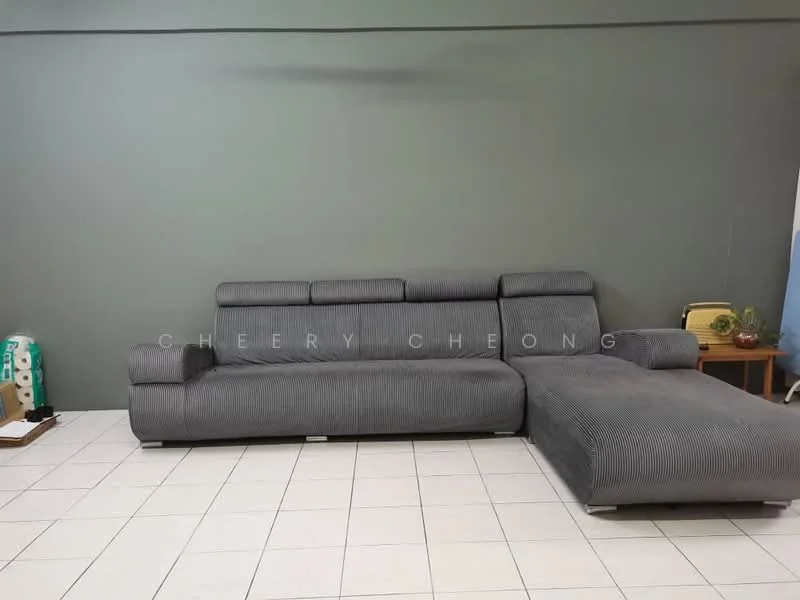 Living features: grey fabric L-shape sectional sofa, white tiled flooring, green painted walls, decorative side table, wall-mounted artwork, floor lamp, window with sheer curtains; style: modern.