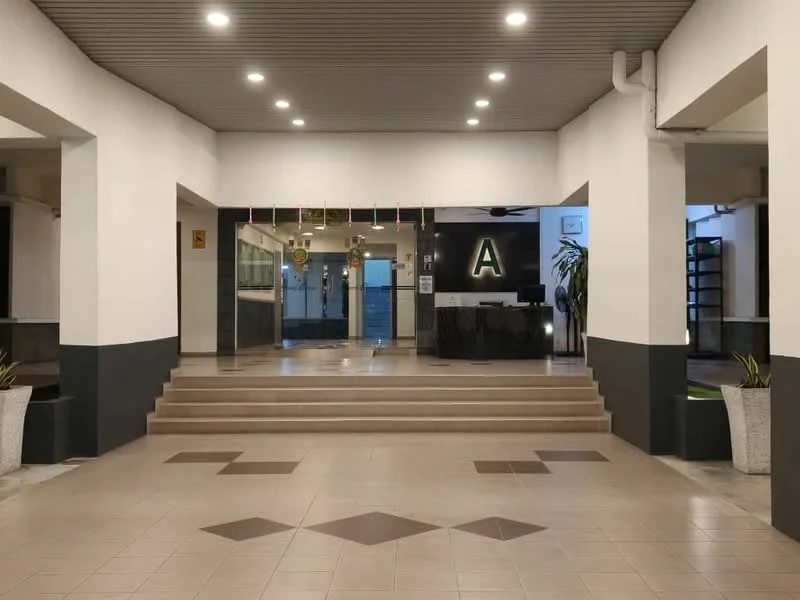 Exterior type: main entrance gate; features: double-volume main lobby, staircase leading to reception area, glass entrance doors, reception desk visible, decorative pendant lighting, potted plants, tiled flooring with geometric pattern, white painted walls, black accent walls, ceiling with recessed lighting; style: modern.