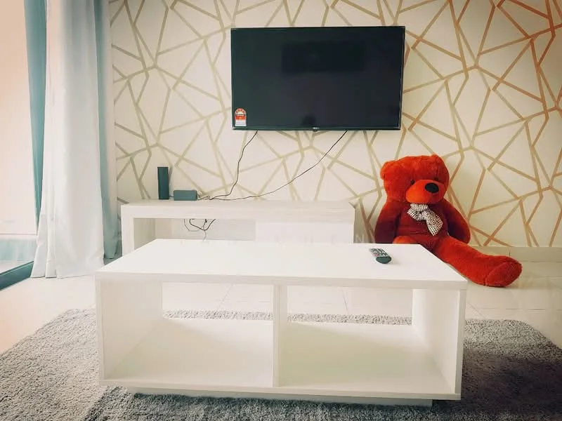 Living features: white coffee table, red teddy bear, wall-mounted TV, grey area rug, white TV console, geometric patterned accent wall, light grey flooring, curtains, black speaker; style: modern.