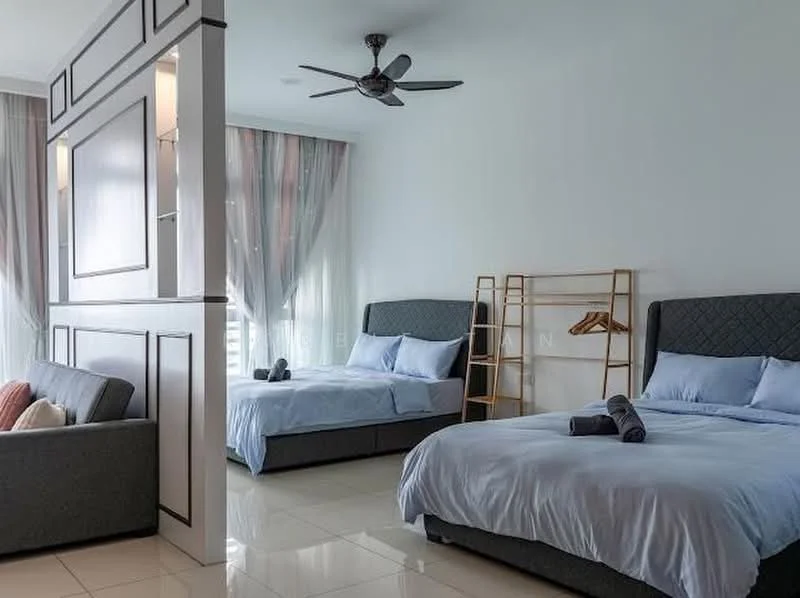 Bedroom features: two queen-size beds with light blue bedding, upholstered headboards, grey fabric sofa, wooden clothing rack, floor-to-ceiling windows with sheer curtains, white painted walls, glossy tile flooring, ceiling fan with light, decorative throw pillows; style: modern.