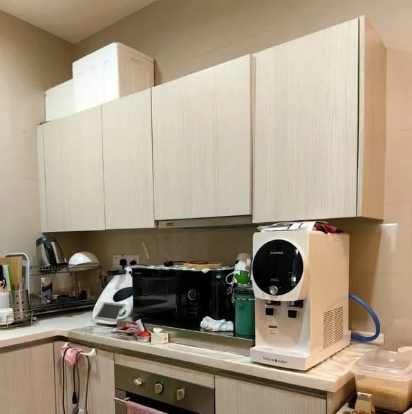 Kitchen features: light wood cabinetry, white countertop, built-in oven, microwave, coffee machine, dish rack, stainless-steel sink, kitchen utensils, wall-mounted cabinets, green storage container; style: modern.