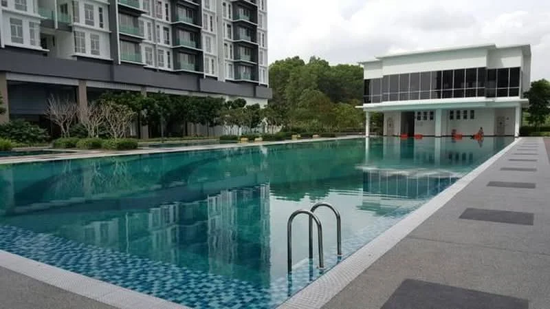 Exterior type: high-rise condominium; features: infinity pool, pool deck with loungers, landscaped garden, manicured lawn, glass facade on clubhouse, surrounded by greenery, paved walkway, multiple storeys visible; style: modern.