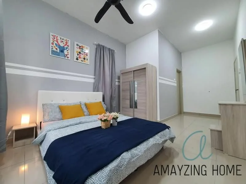 Bedroom features: queen-size bed with blue and white bedding, upholstered headboard, two yellow decorative pillows, wooden bedside lamp, wooden wardrobe with sliding doors, light grey painted walls, white ceiling, ceiling fan, framed artwork on walls, curtains in grey, glossy tile flooring; style: modern.