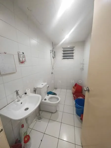 Bathroom features: white tiled walls, white tiled flooring, single-sink vanity with chrome faucet, one-piece toilet, shower with handheld shower head, window for natural light, mirror above sink, cleaning supplies in red buckets.