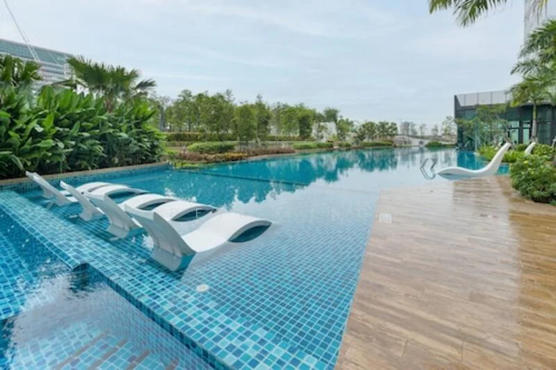 Exterior type: swimming pool deck; features: infinity pool, tiled pool deck with blue mosaic tiles, wooden decking area, lounge chairs by the pool, lush tropical landscaping, surrounding greenery, palm trees, water feature, sun loungers, poolside garden beds; style: modern.