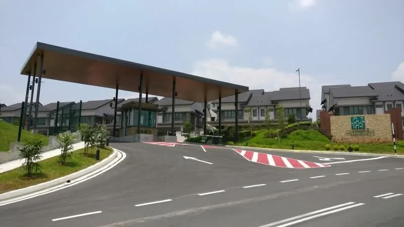 Exterior type: gated community; features: guard house at entrance, double-volume main lobby, manicured lawn, paved driveway, landscaped greenery, multi-storey residential buildings, signage at entrance, surrounded by mature trees; style: modern.