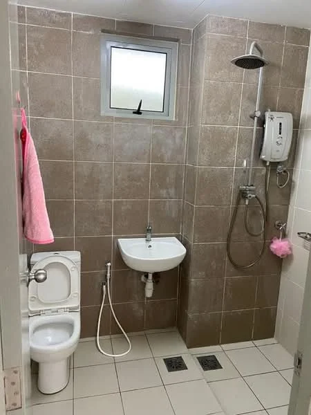 Bathroom features: brown tiled walls, white ceramic sink, chrome basin mixer faucet, shower with handheld showerhead, wall-mounted shower unit, white toilet, bidet spray, grey tiled flooring, small window, pink towel hanging, pink loofah hanging; style: modern.