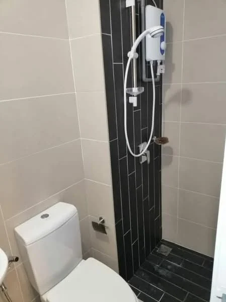 Bathroom features: white one-piece toilet, walk-in shower with glass enclosure, chrome handheld shower head, black and white tile flooring, grey wall tiles, shower mixer, shower wall with vertical tiles, toilet paper holder; style: modern.