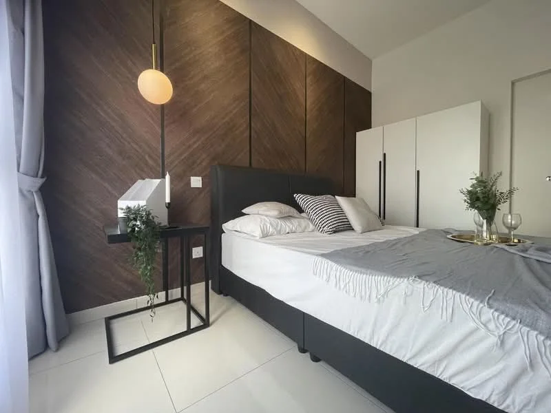 Bedroom features: queen-size bed, upholstered headboard, white bedding, decorative throw pillows, black bedside table, pendant light fixture, wood accent wall, white wardrobe with black handles, grey throw blanket, floor-to-ceiling window with sheer curtains, white ceramic vase, greenery in vase, glass of wine, decorative tray; style: modern.