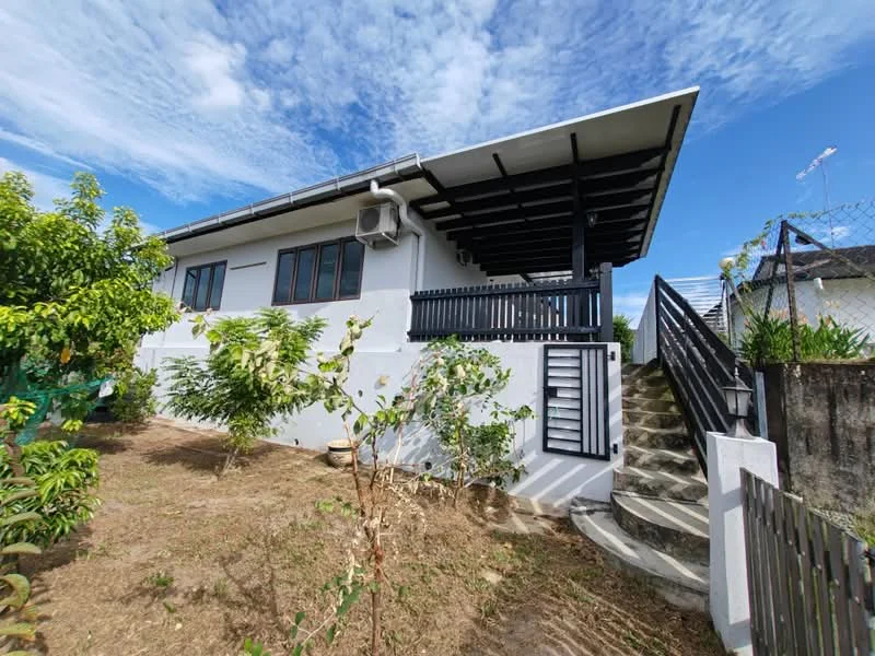 Exterior type: detached bungalow; features: white painted facade, flat roof, single-storey, manicured lawn, mature trees, staircase leading to entrance, fenced perimeter, air conditioning unit visible, outdoor greenery, garden area; style: modern.