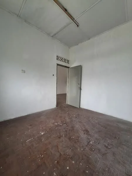 Room features: white painted walls, wooden flooring, single door, ceiling with exposed beams, no visible windows, minimal decor.